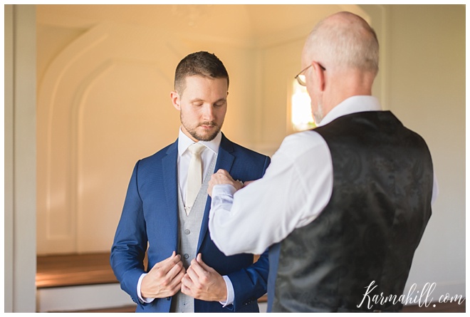 groom putting on a boutonnière 