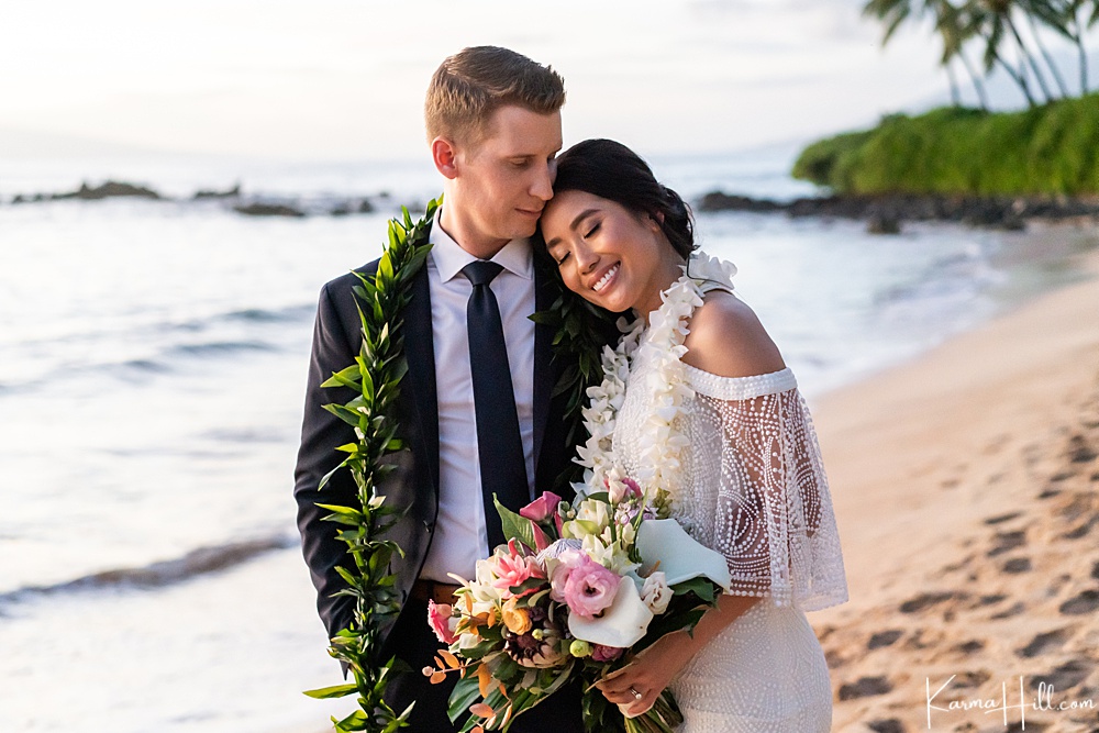 bride and groom embracing on a beach - top maui wedding photographer 