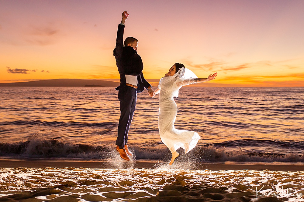 Bride and groom leaping on a beach - maui sunset 