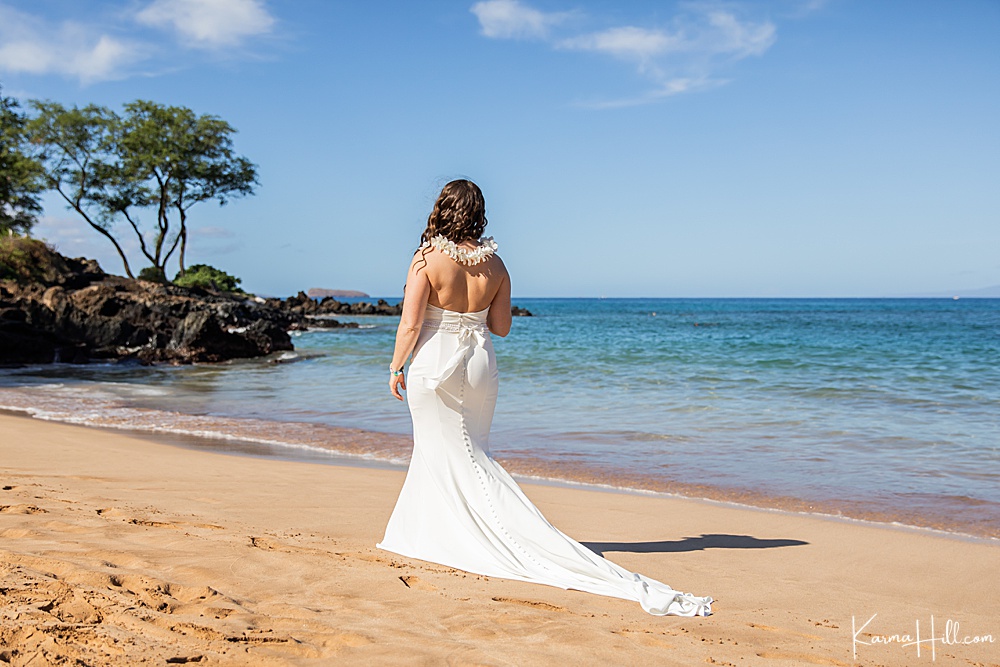 bride wearing a long button down wedding gown on Maui beach 