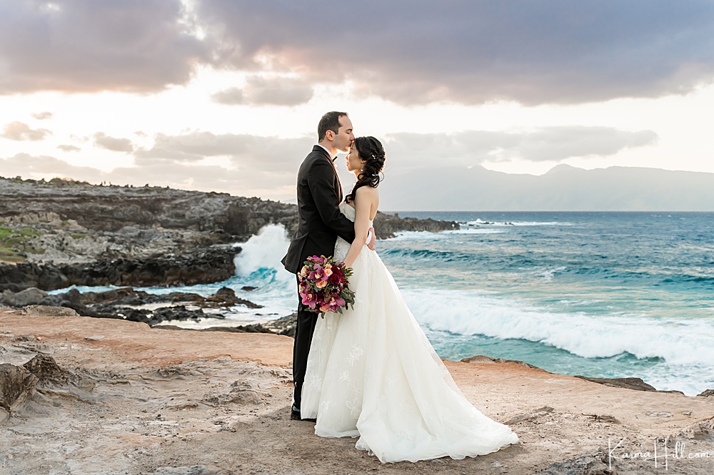 bride and groom kissing by Maui cliff and ocean - best maui wedding packages 