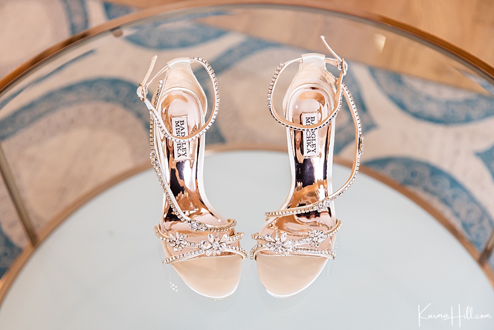gemstone bridal shoes on a clear table 