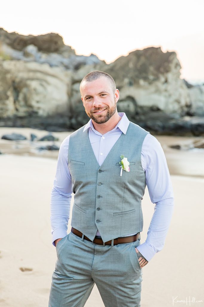groom in lilac shirt and pewter colored vest on beach 