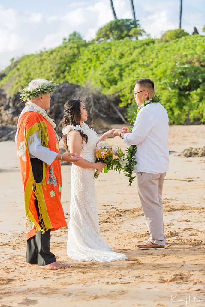 bride and groom exchange rings on maui beach 