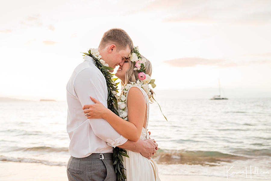 bride and groom embrace on the beach 