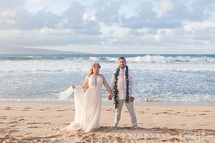 bride and groom in front of ocean waves 