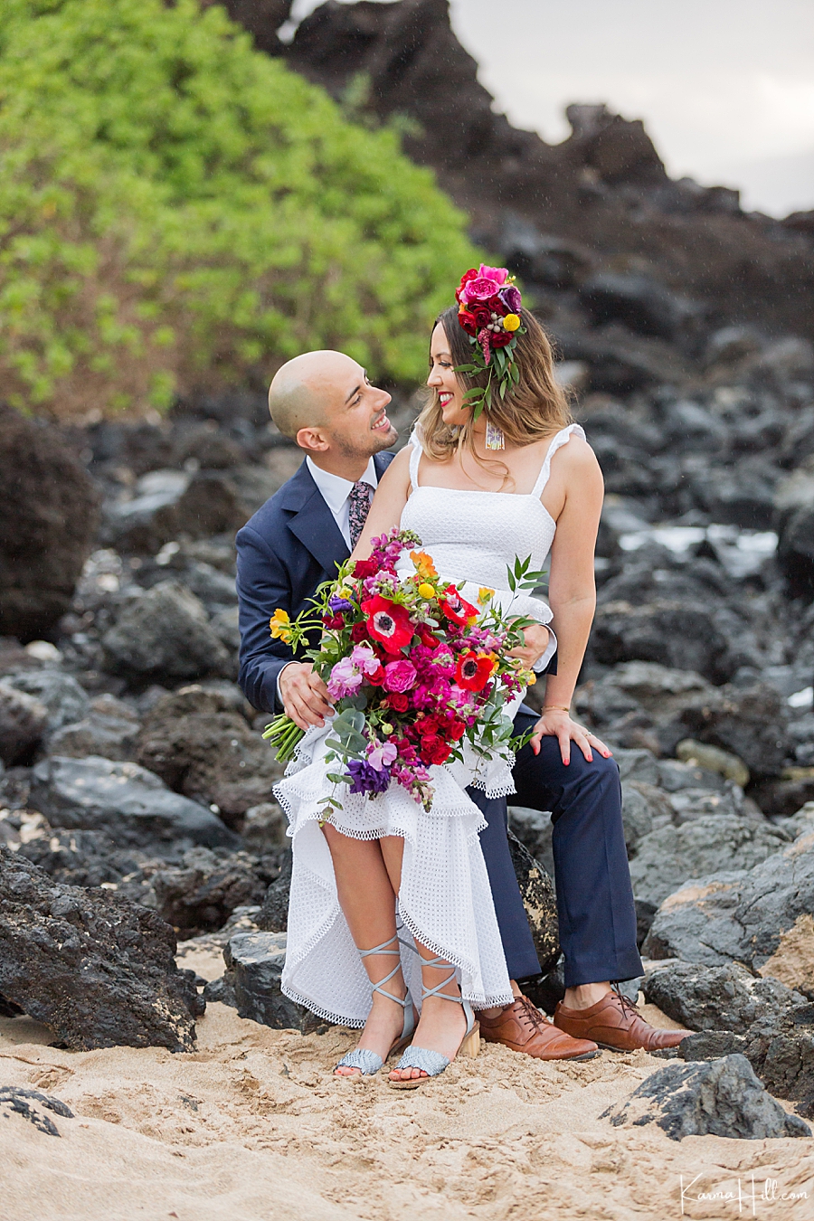 bride and groom pose on lava rocks for their maui beach wedding 