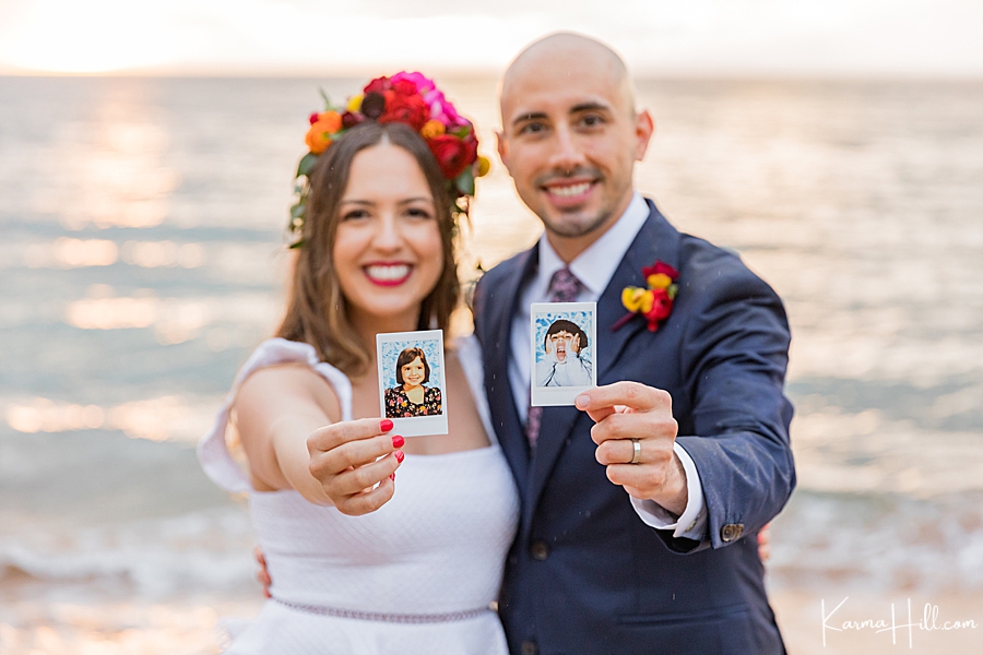 bride and groom hold photos of themselves as children 
