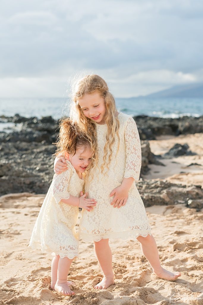 sweet flower girl photo on maui beach with lava rocks and ocean in the background 