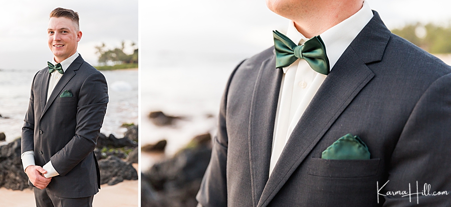 groom poses wearing a forest green bowtie and black and white tuxedo 