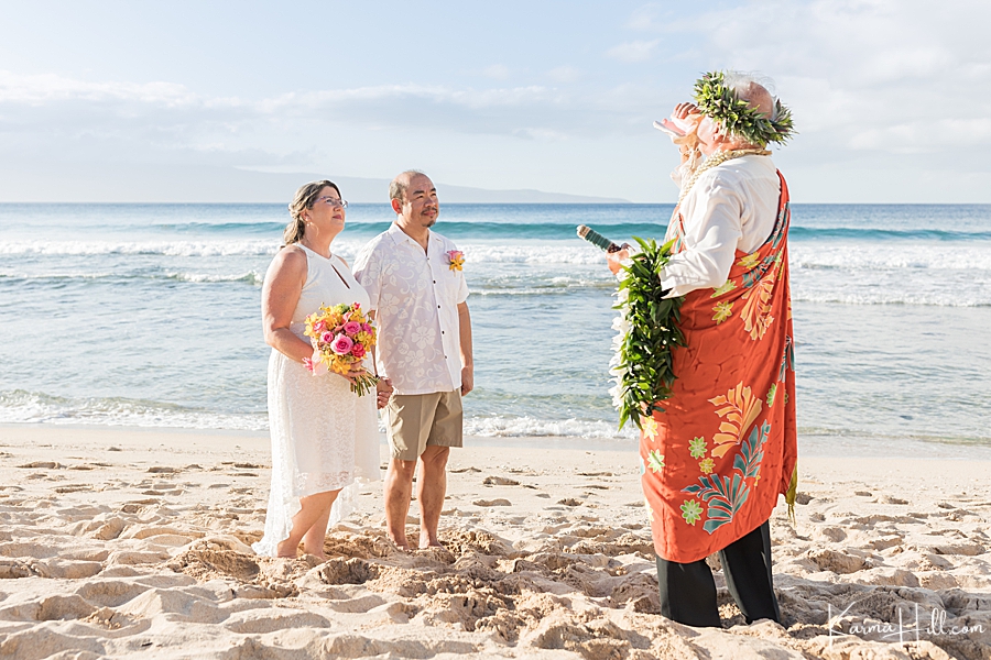 hawaiian minister blows the conch shell as a couple elopes in maui 