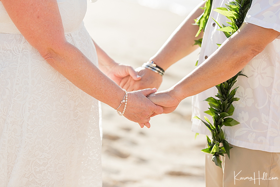 bride and groom hold hands during their hawaii wedding 
