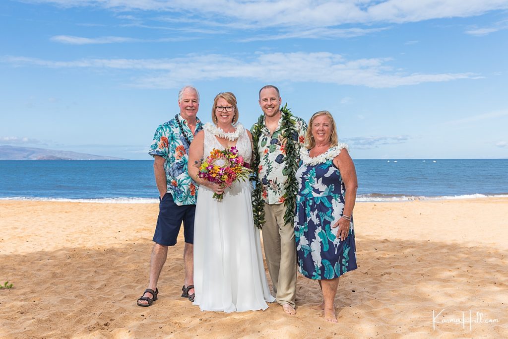 family gathers for photos after beach wedding 