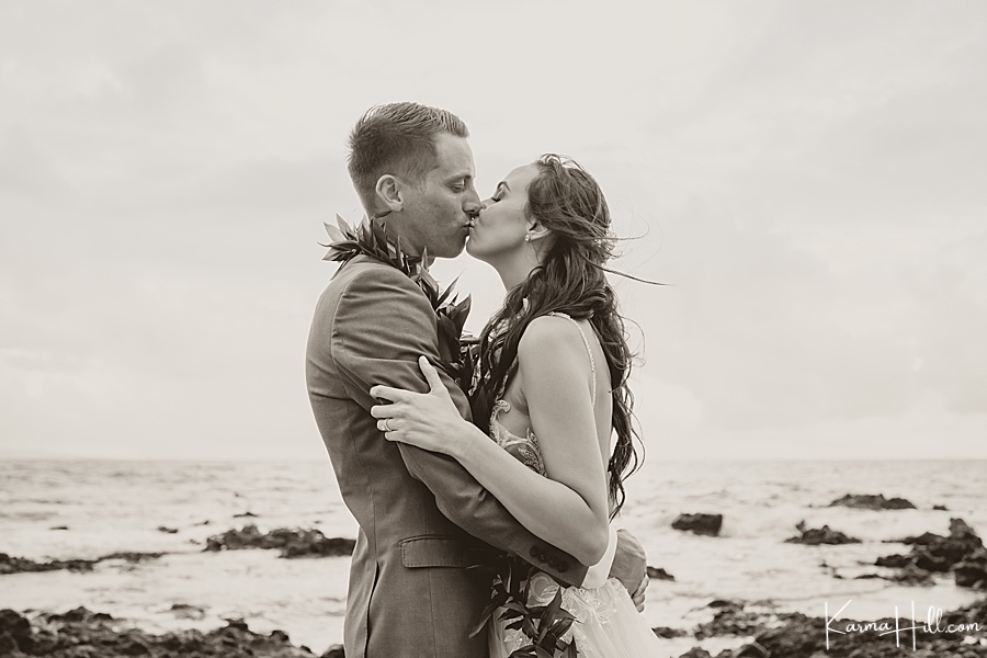black and white photo of bride and groom kissing on maui beach 