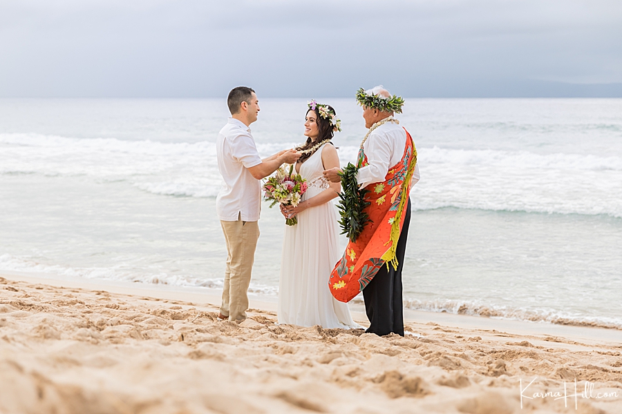 bride and groom exchange leis during their wedding in hawaii 