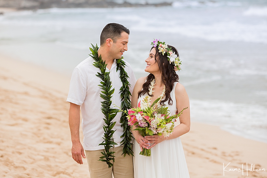 bride and groom look at each other after wedding on maui beach. 