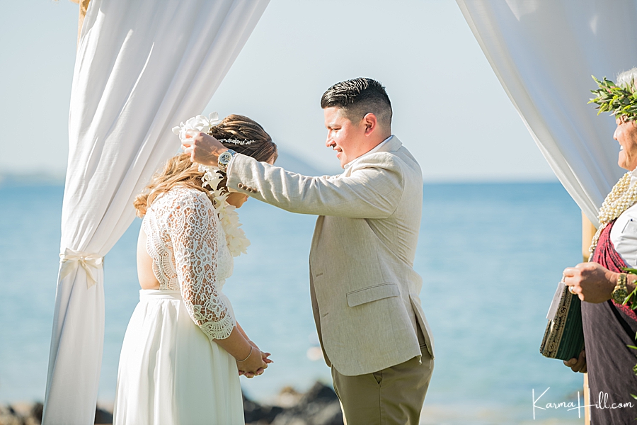 groom gives his bride a lei for their hawaii wedding 