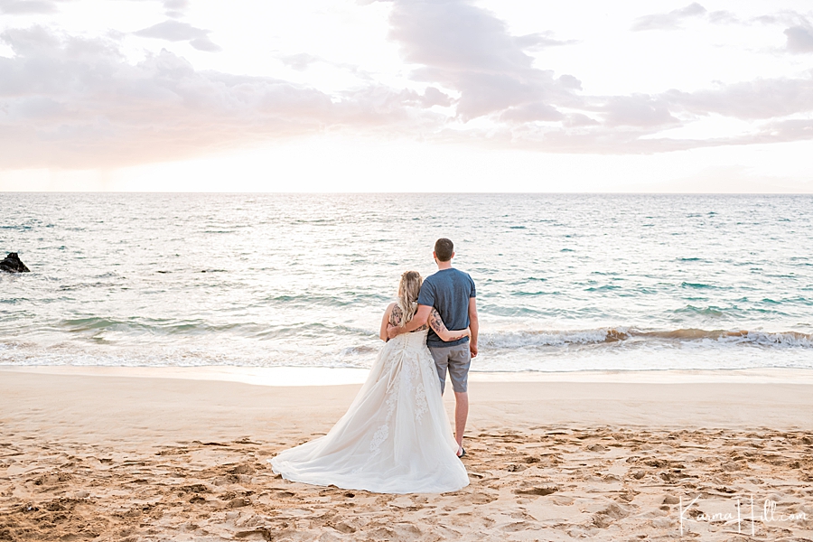 bride and groom looking off into a maui sunset 