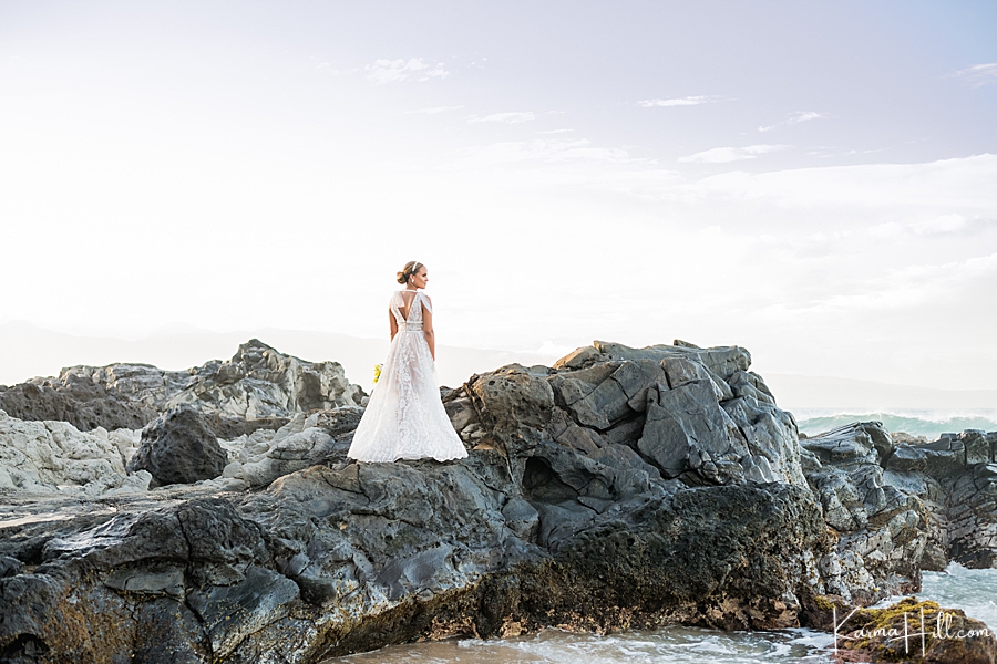 bride standing on maui lava rocks overlooking the ocean 