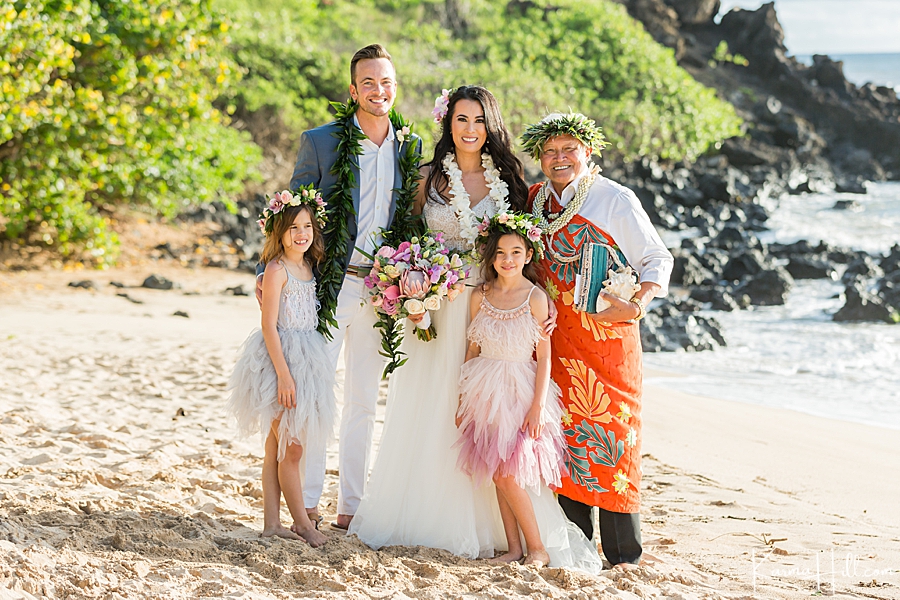 husband and wife and two daughters pose with maui minister for their maui vow renewal 
