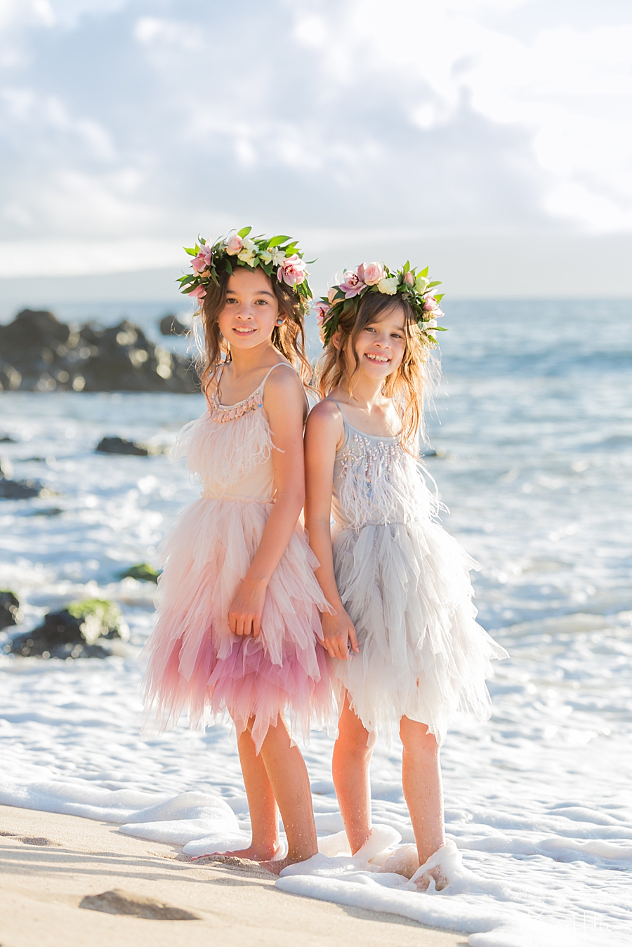 flower girl hawaii wedding - two girls wearing pink and light blue dresses pose on maui shore 