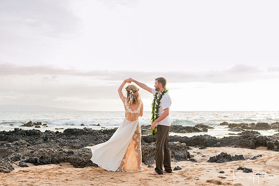 husband and wife dance after wedding on a rocky tropical beach 