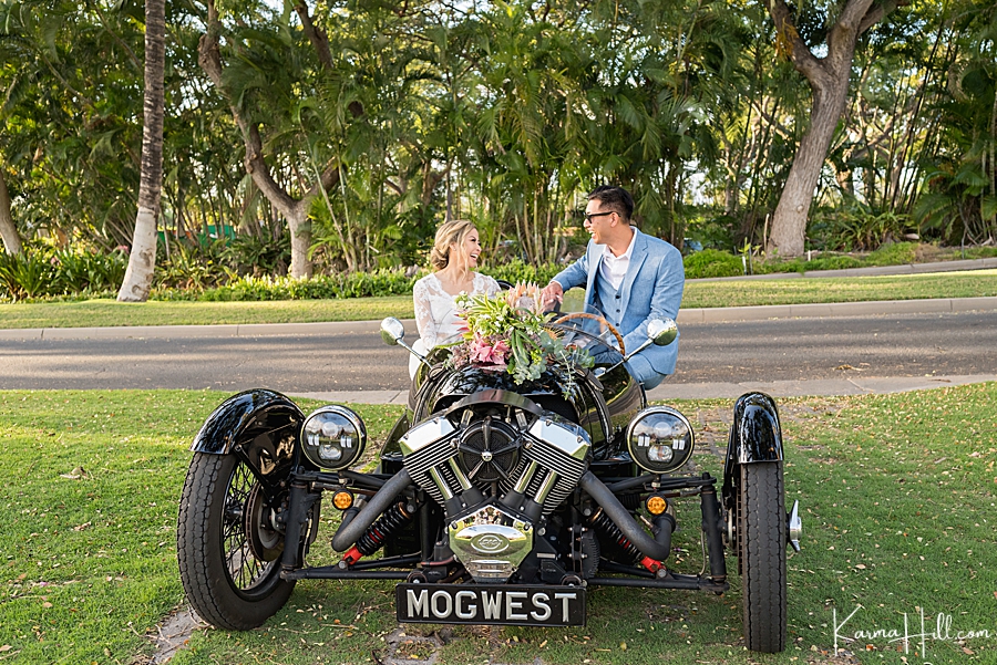 couple just married in hawaii sit in a rented mogwest automobile for the wedding 