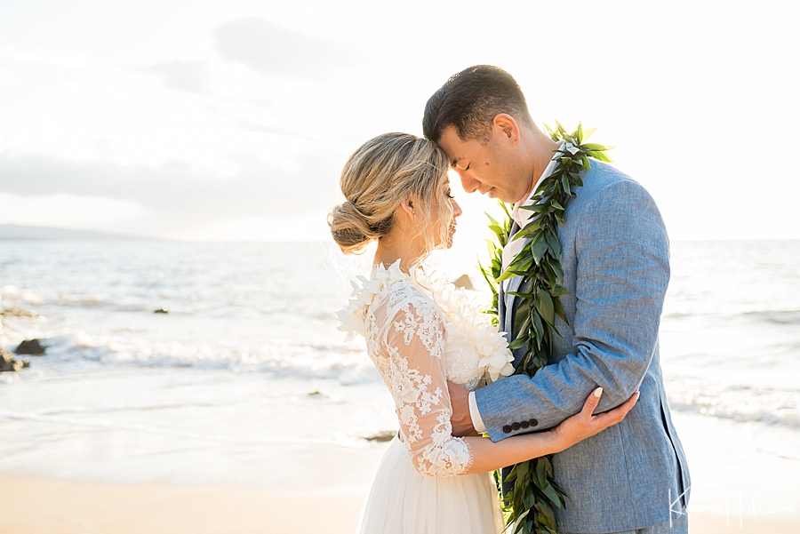 couple touch forheads on the beach during their wedding in hawaii 