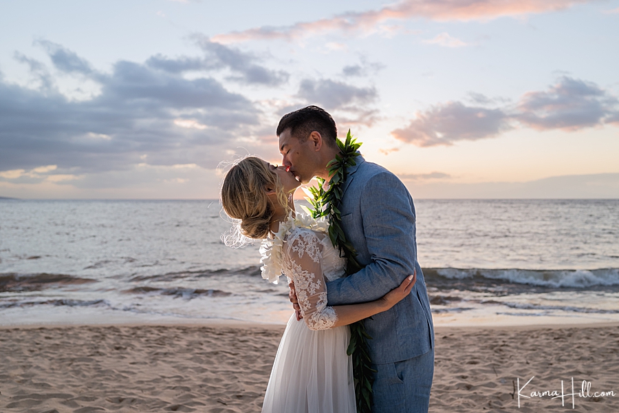  just married couple kiss in front of a hawaii sunset 