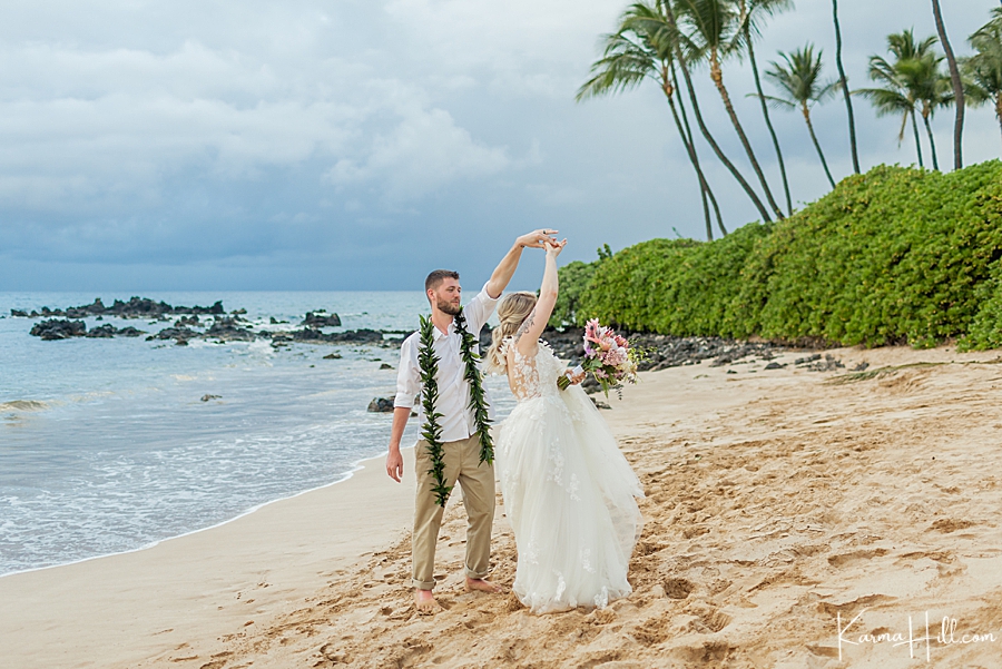 groom twirls bride on hawaii beach 