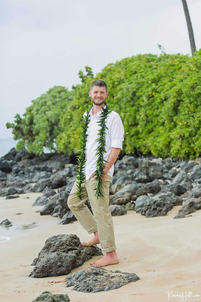 groom in maile lei with khaki slacks and white shirt 