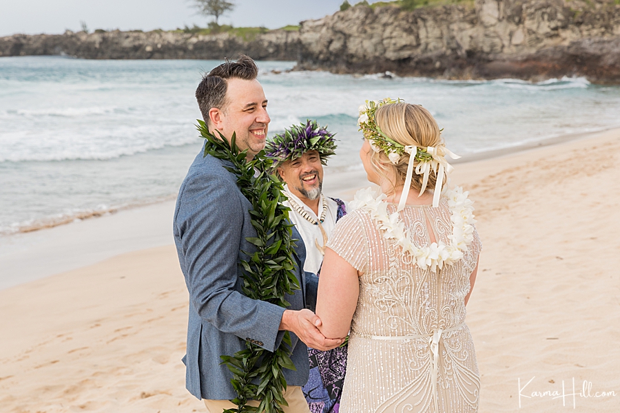 candid photo of bride and groom laughing with their minister during their hawaii wedding 