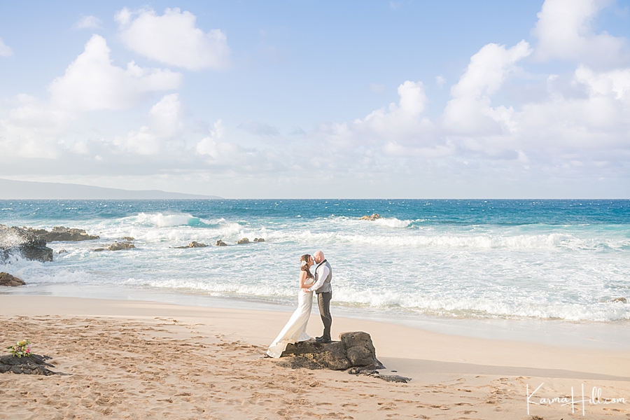 bride and groom in front of a turquoise ocean 