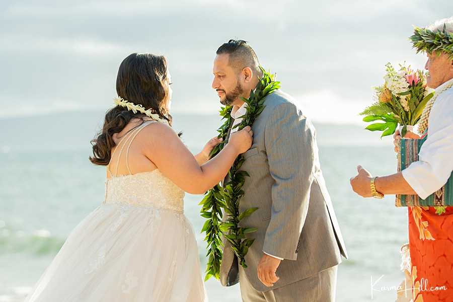 bride gives groom a maile lei during hawaii elopement 