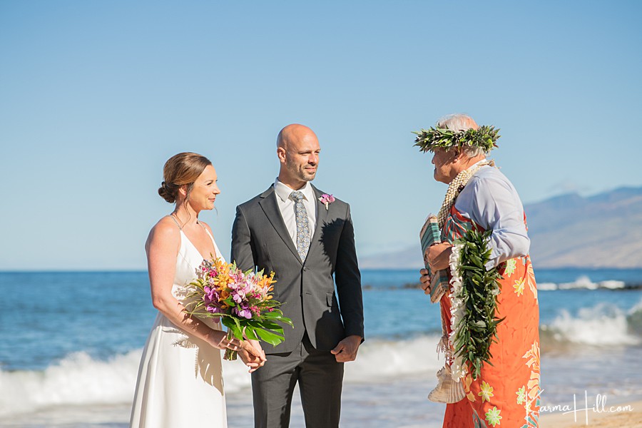hawaiian minister wearing a haku lei oversees a beach wedding in hawaii 
