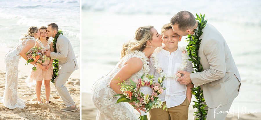 bride and groom kiss their children on the cheek during their wedding in hawaii 
