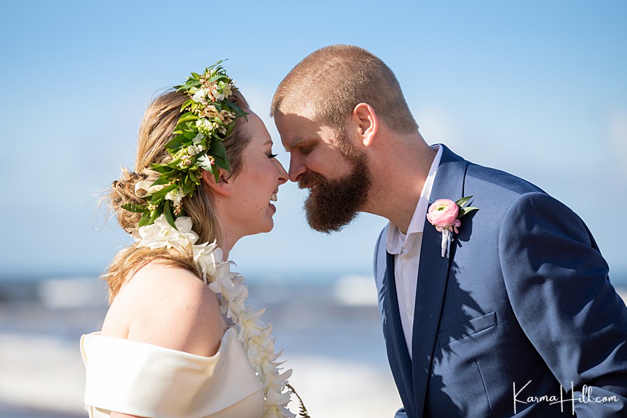 bride and groom touch noses during their maui wedding 