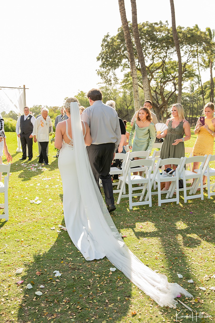bride walks down the aisle with her father at gannon's on maui 