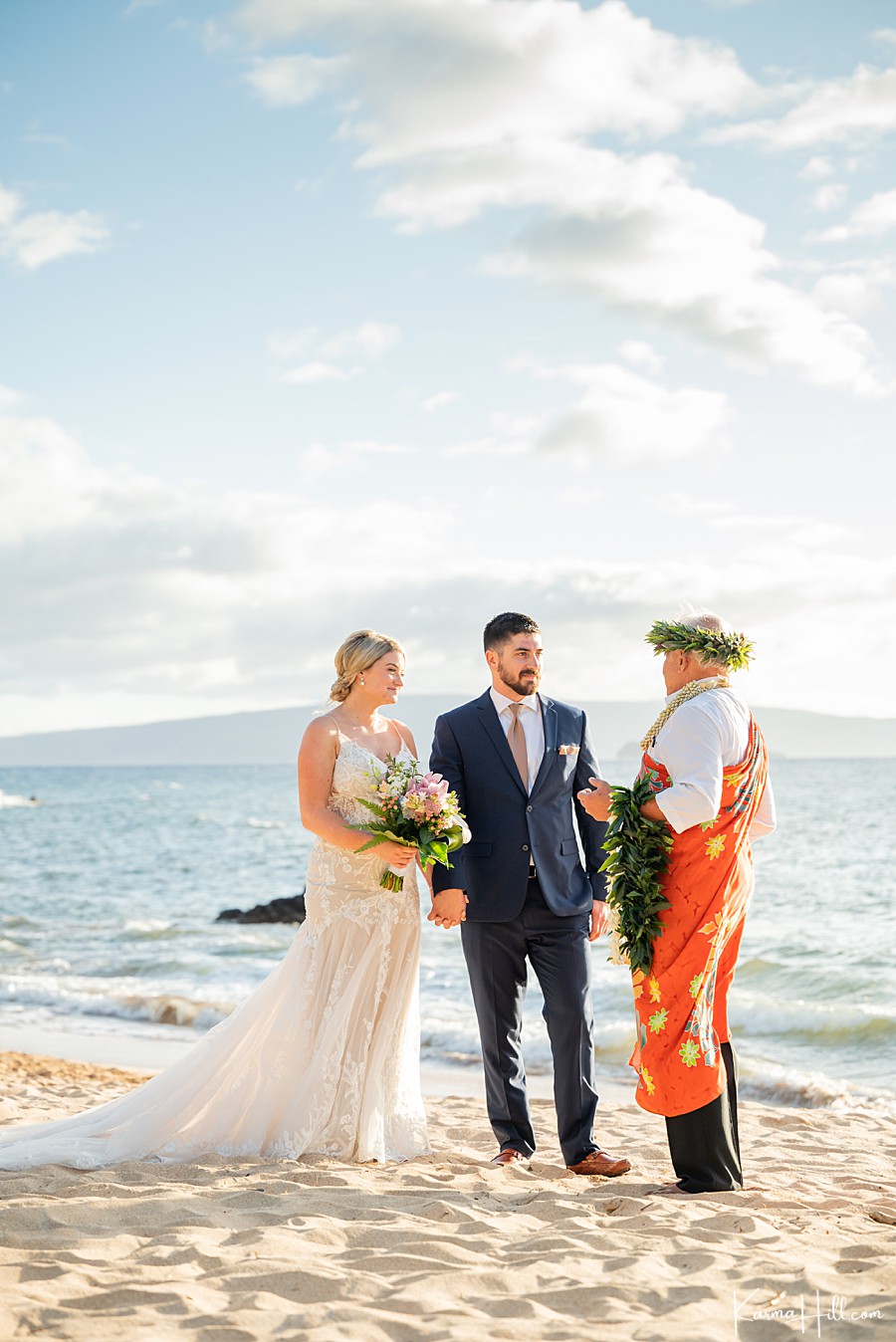 couple getting married on hawaii beach stand with their hawaiian minister 