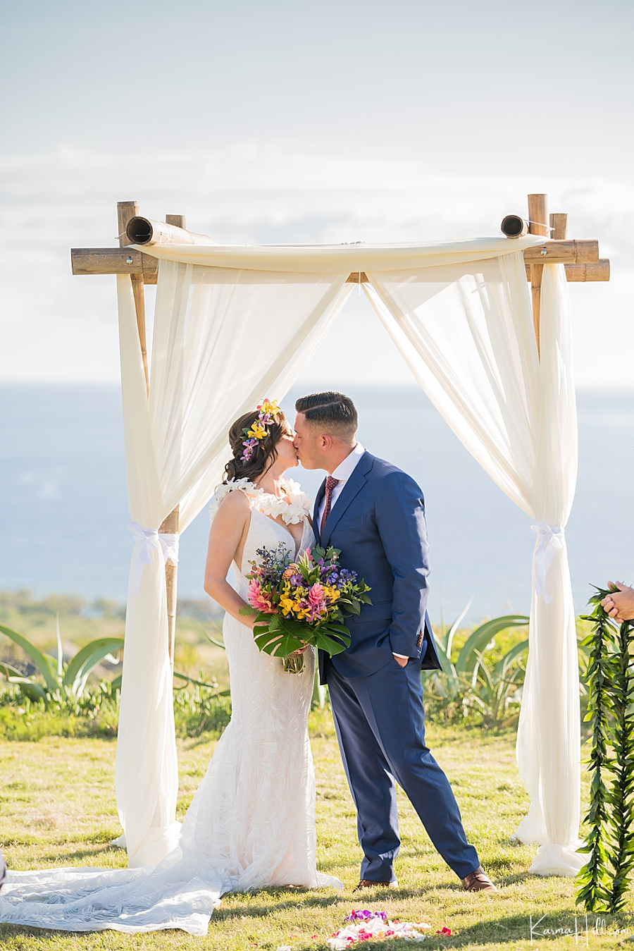 bride and groom kiss under an archway in the dragon fruit farm on maui 