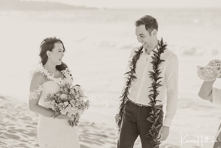 black and white image of husband and wife smiling during their hawaii wedding on the beach 