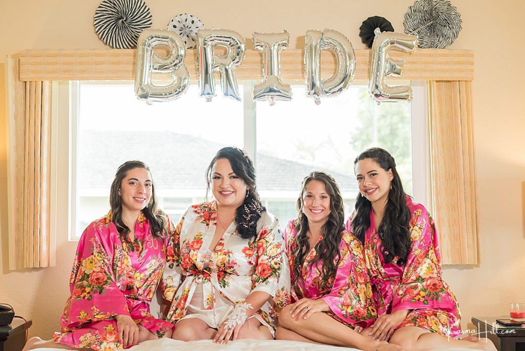 bride and girls in pink kimono robes celebrate with bride spelled in balloons in their hotel 