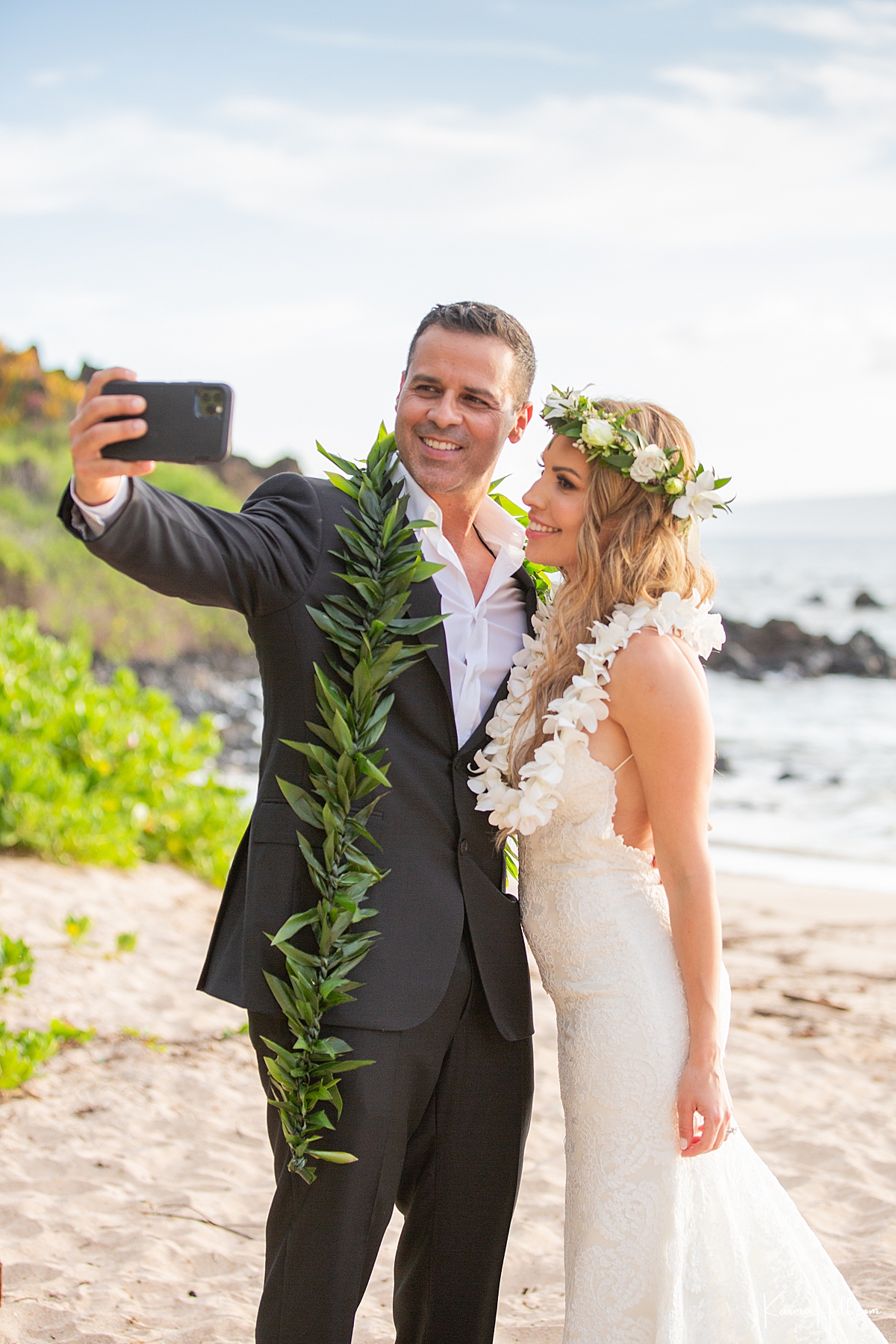 bride and groom take a selfie after getting married on maui beach 