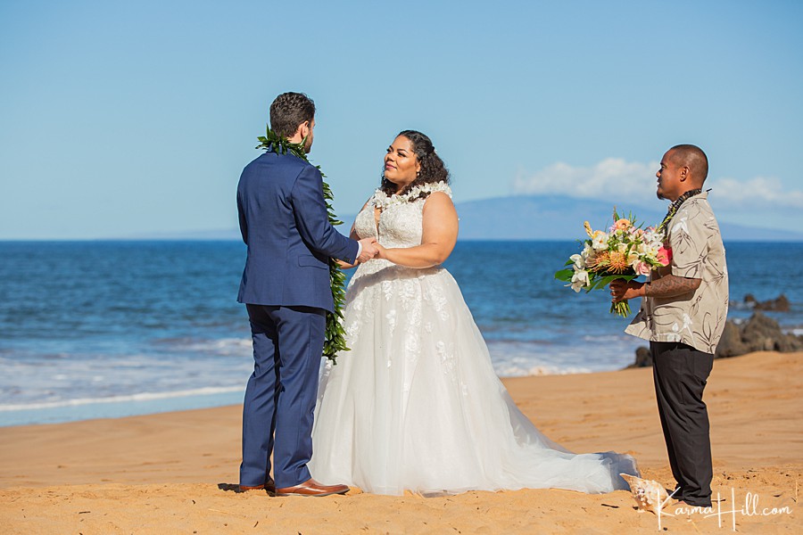 bride and groom exchange vows during maui wedding on the beach 