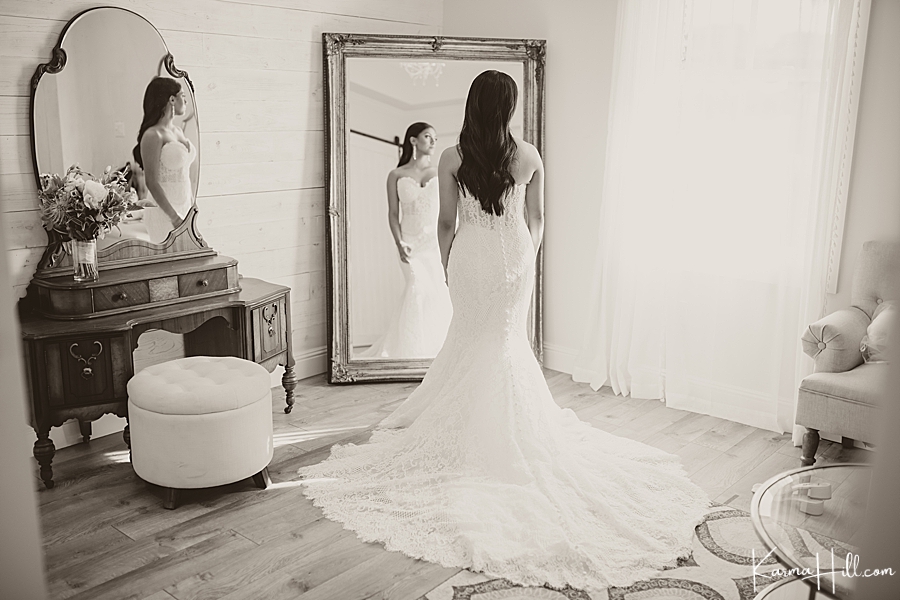 black and white image of bride looking at herself in the mirror 