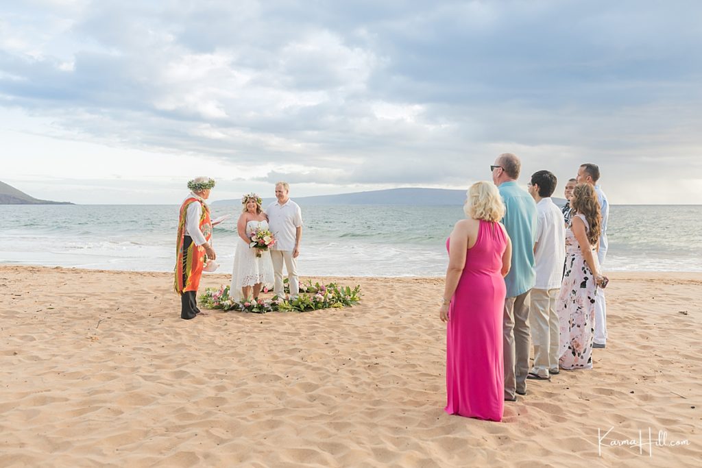 bride and groom stand in lei circle on maui beach 