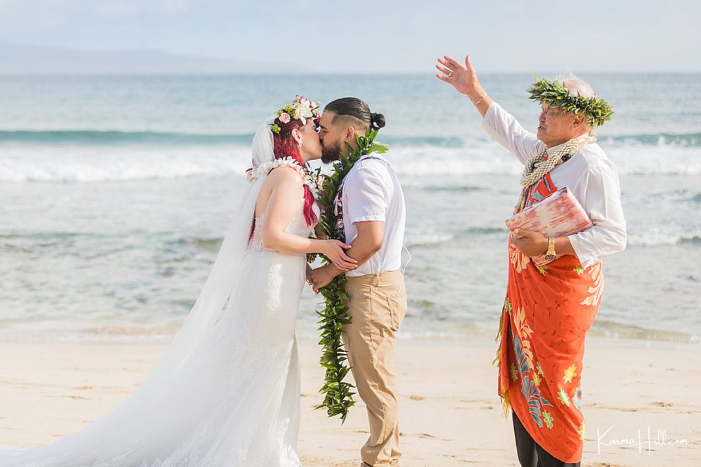 hawaiian minister pronounces couple husband and wife with ocean in the background 