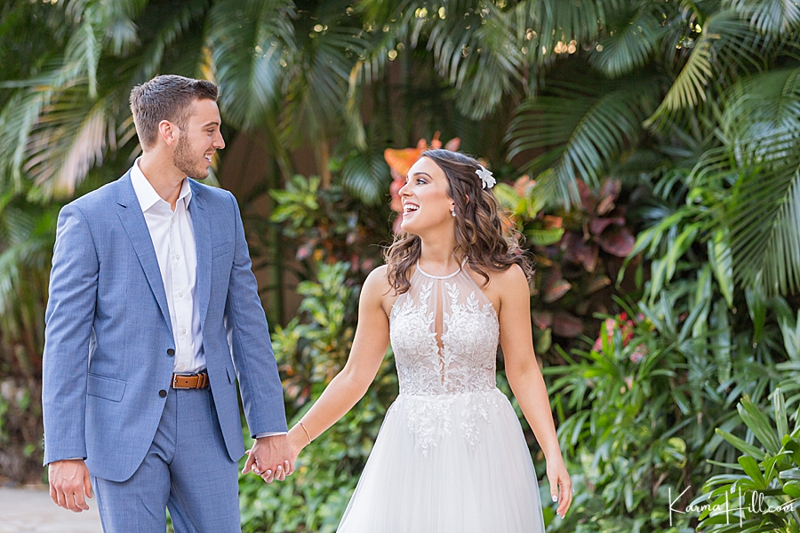 sweet couple getting married in hawaii with modern dress and tropical foliage 