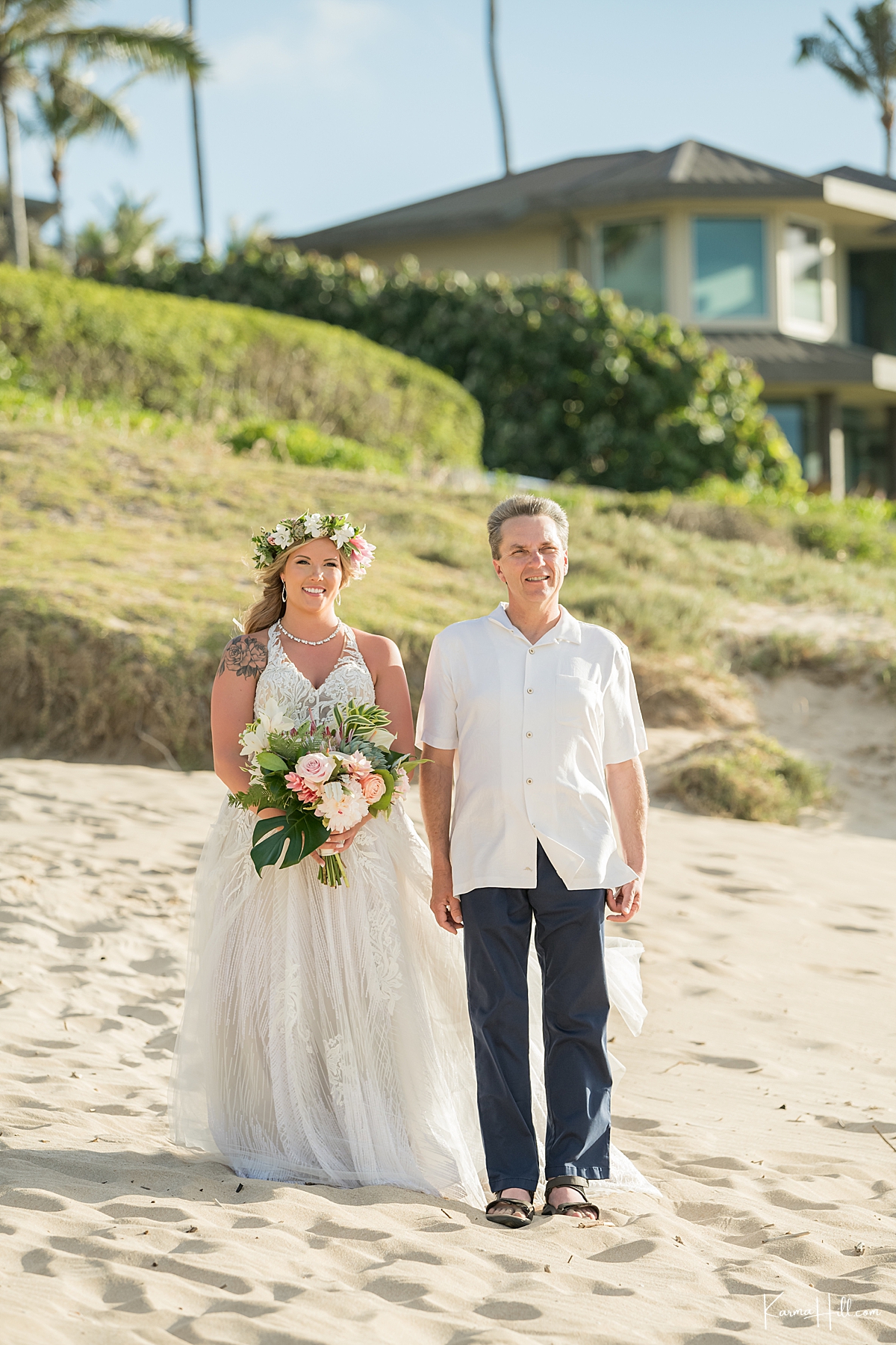 bride wearing a haku lei walks down the aisle during her beach wedding 