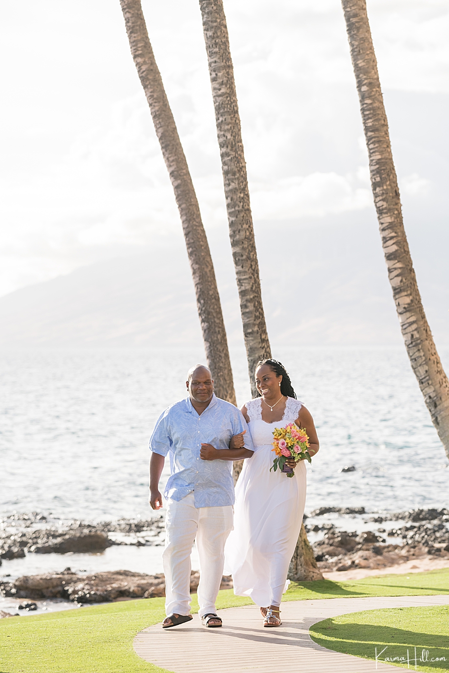 bride is walked down the aisle of her hawaii wedding by her father 